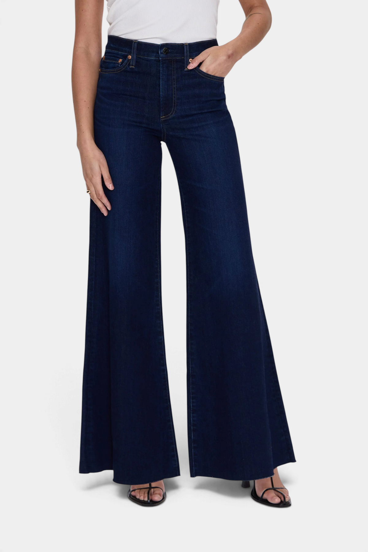 The Copper Shed Pistola Izzy high rise wide leg jeans in dark wash denim worn with a white top and black sandals