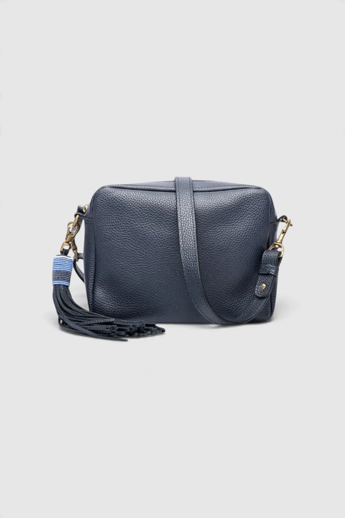 The Copper Shed Princess small navy blue leather crossbody bag with a long decorative tassel and adjustable strap.