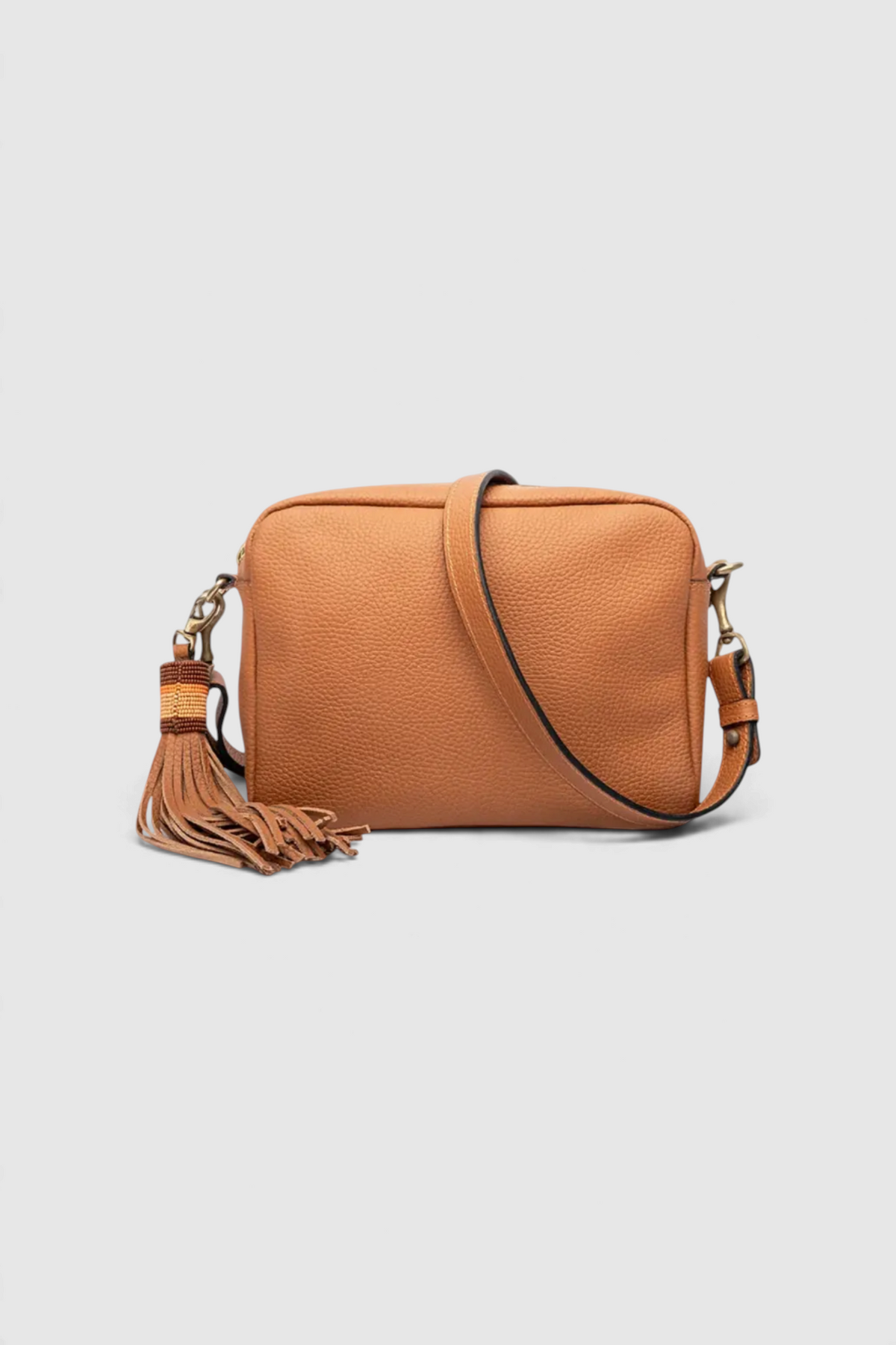 The Copper Shed Princess small tan leather crossbody bag with a long decorative tassel and adjustable shoulder strap.