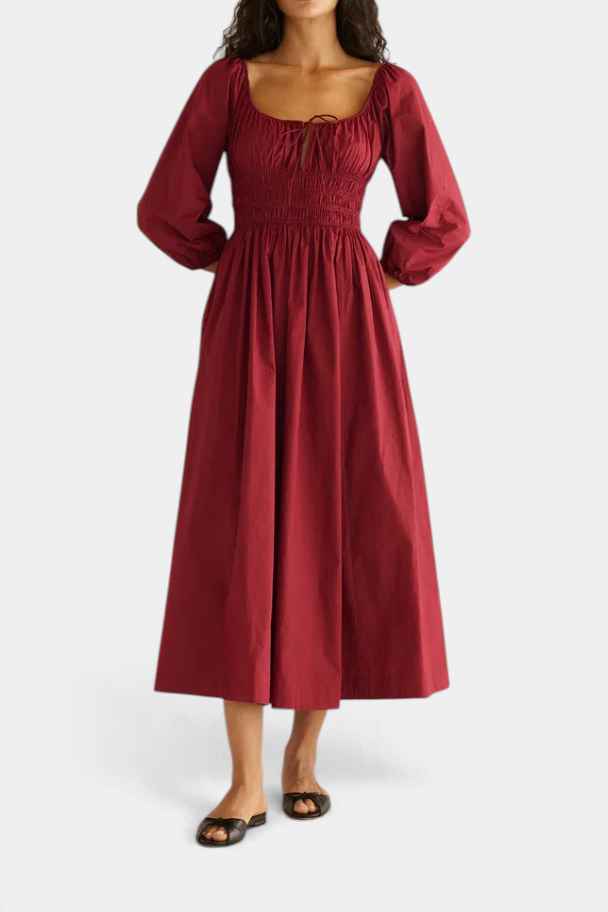 The Copper Shed Quintessa midi dress in deep red organic cotton poplin with smocked bodice and bracelet-length sleeves