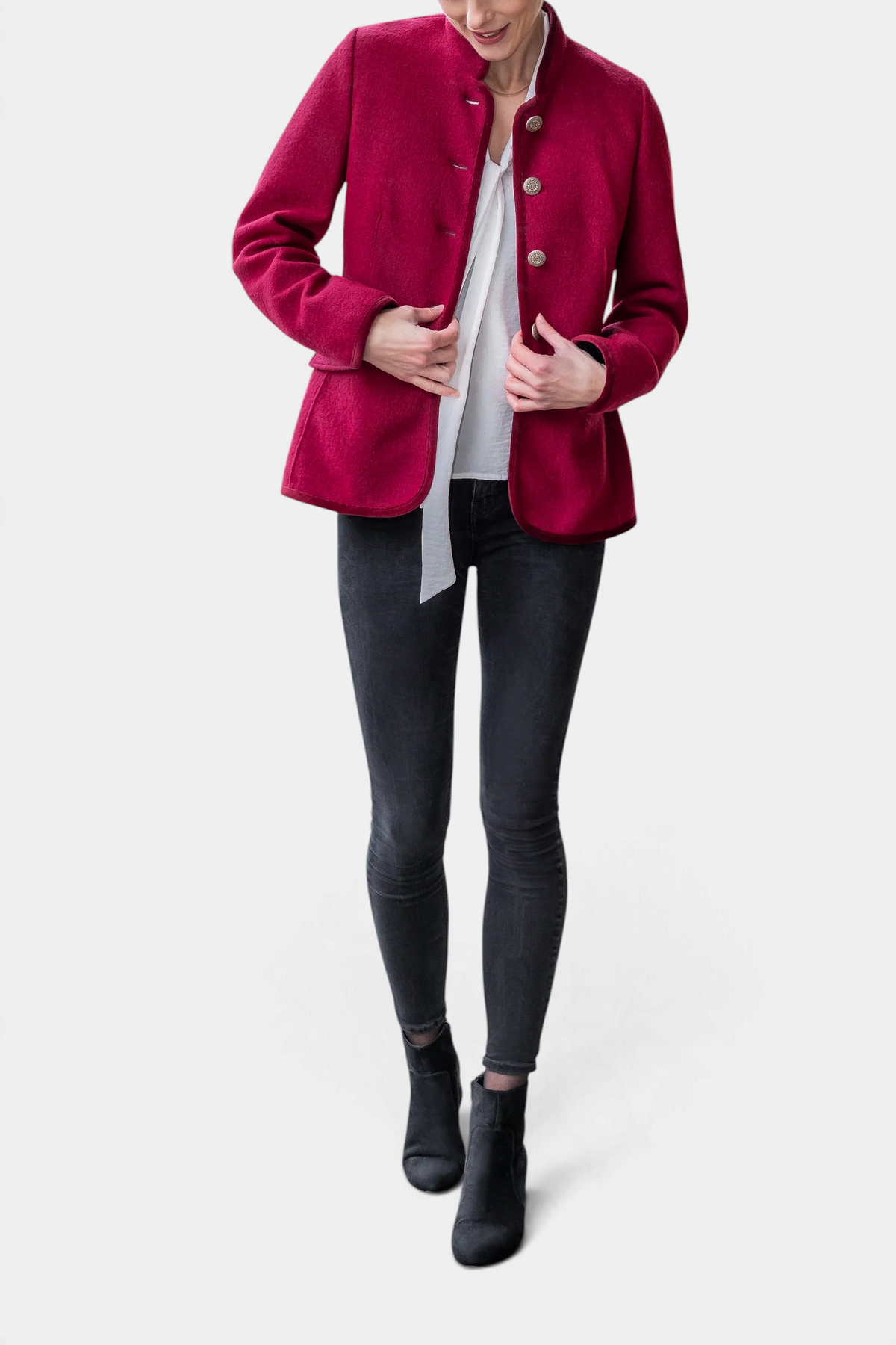 The Copper Shed Lara red boiled wool Austrian cardigan with metallic buttons and stand collar worn by a model.
