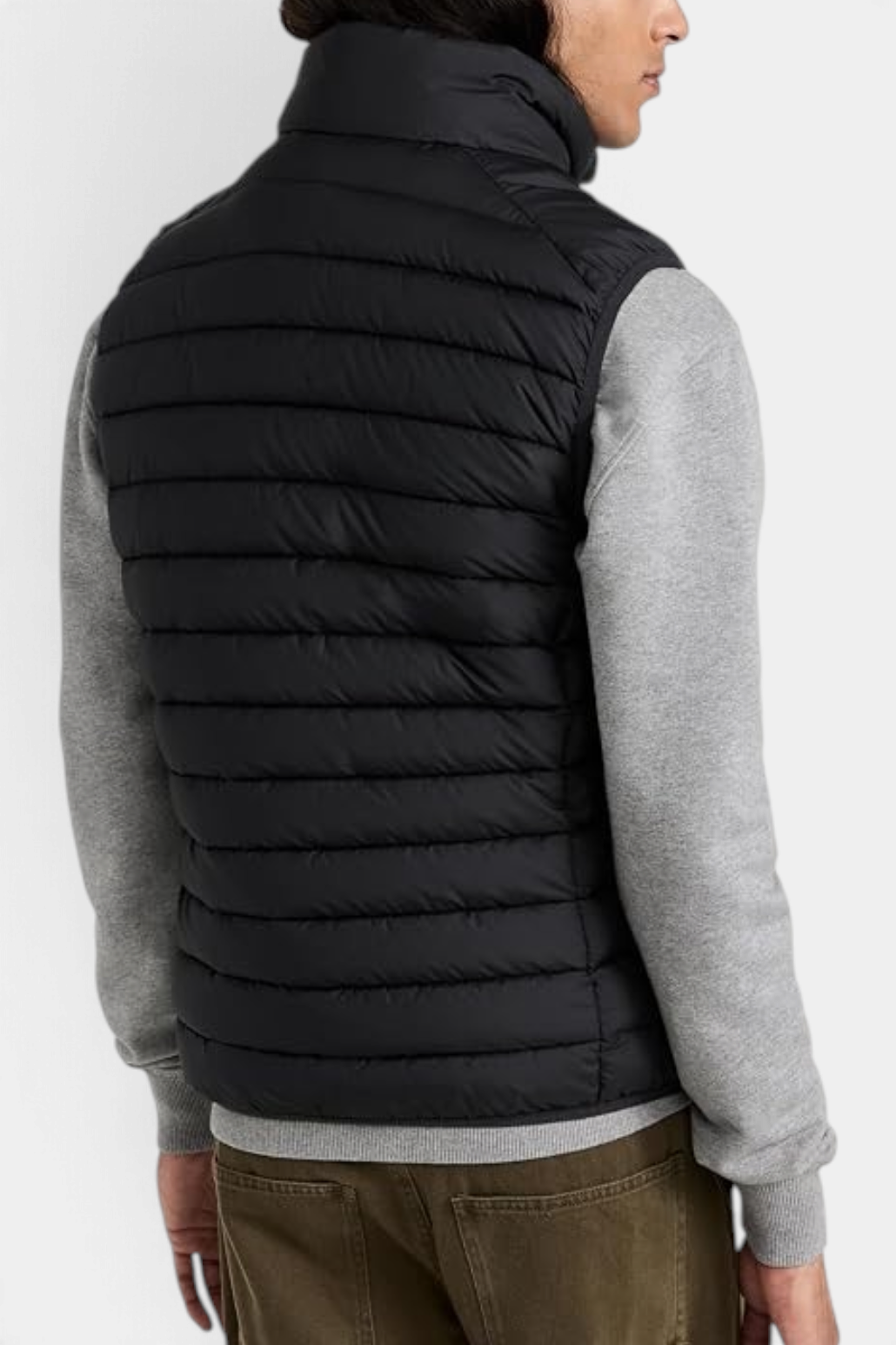 The Copper Shed Rhus men's black quilted puffer vest with stand-up collar, worn over a grey sweater, back view.