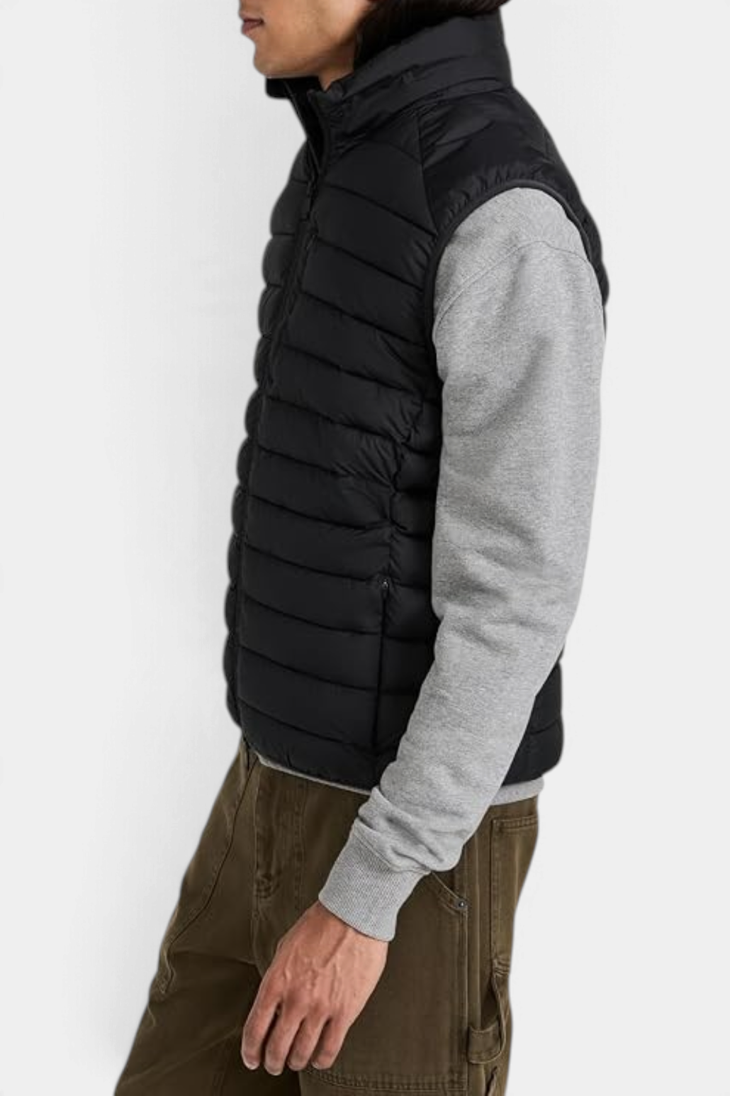The Copper Shed Rhus men's black quilted puffer vest with stand-up collar and zippered pockets, side view.