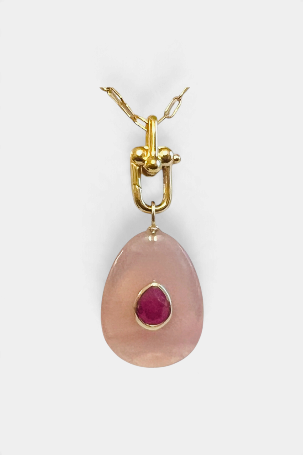 The Copper Shed Atlanta rose quartz pendant necklace featuring a ruby center stone on a 14k gold fill carabiner chain.