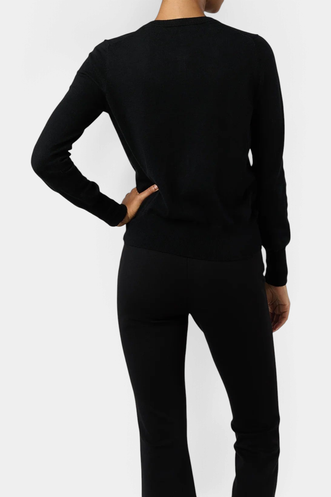 Back view of The Copper Shed Rosie cardigan in black cotton-silk knit with ribbed hem and cuffs on a model