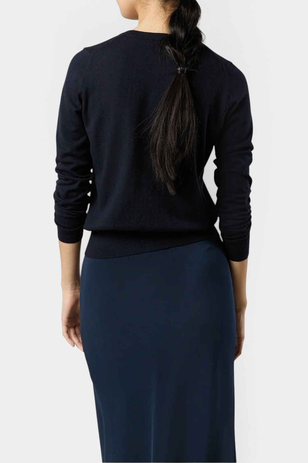 The Copper Shed Rosie cardigan in navy blue cotton-silk knit, worn as a long-sleeve top, back view on a model.