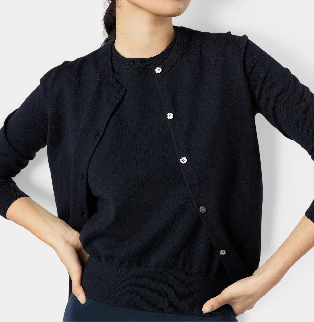 The Copper Shed Rosie cardigan in navy cotton-silk knit with jewel neckline and smoke mother-of-pearl buttons.