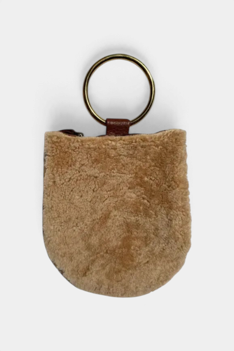 The Copper Shed cream shearling mini wristlet with brown leather trim and antique brass ring handle