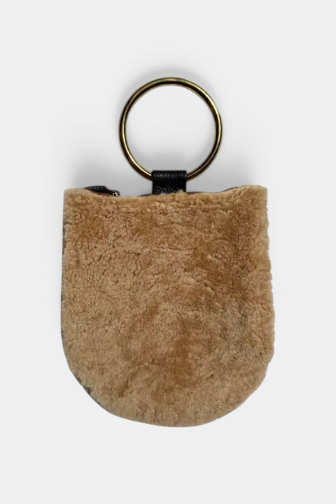 The Copper Shed cream shearling mini wristlet with brown leather trim and antique brass ring handle
