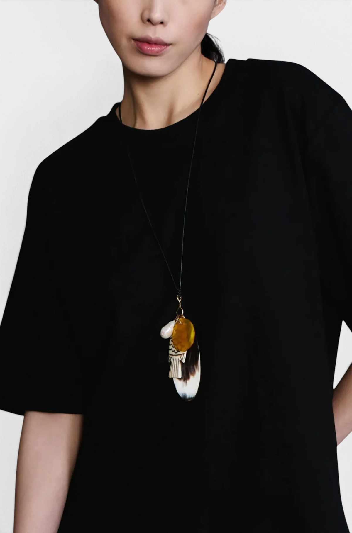 The Copper Shed Shoal Charm Necklace featuring mixed pendants of gold, horn, bone fish, resin, and a baroque pearl.