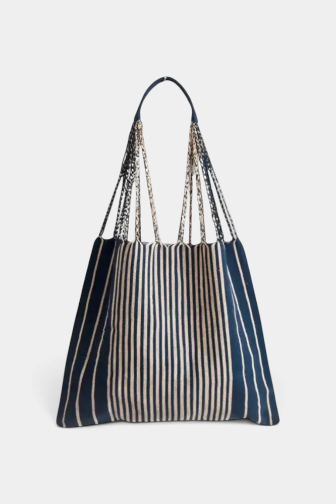 The Copper Shed handwoven striped hammock bag in navy and cream with braided straps, perfect for beach or market use.