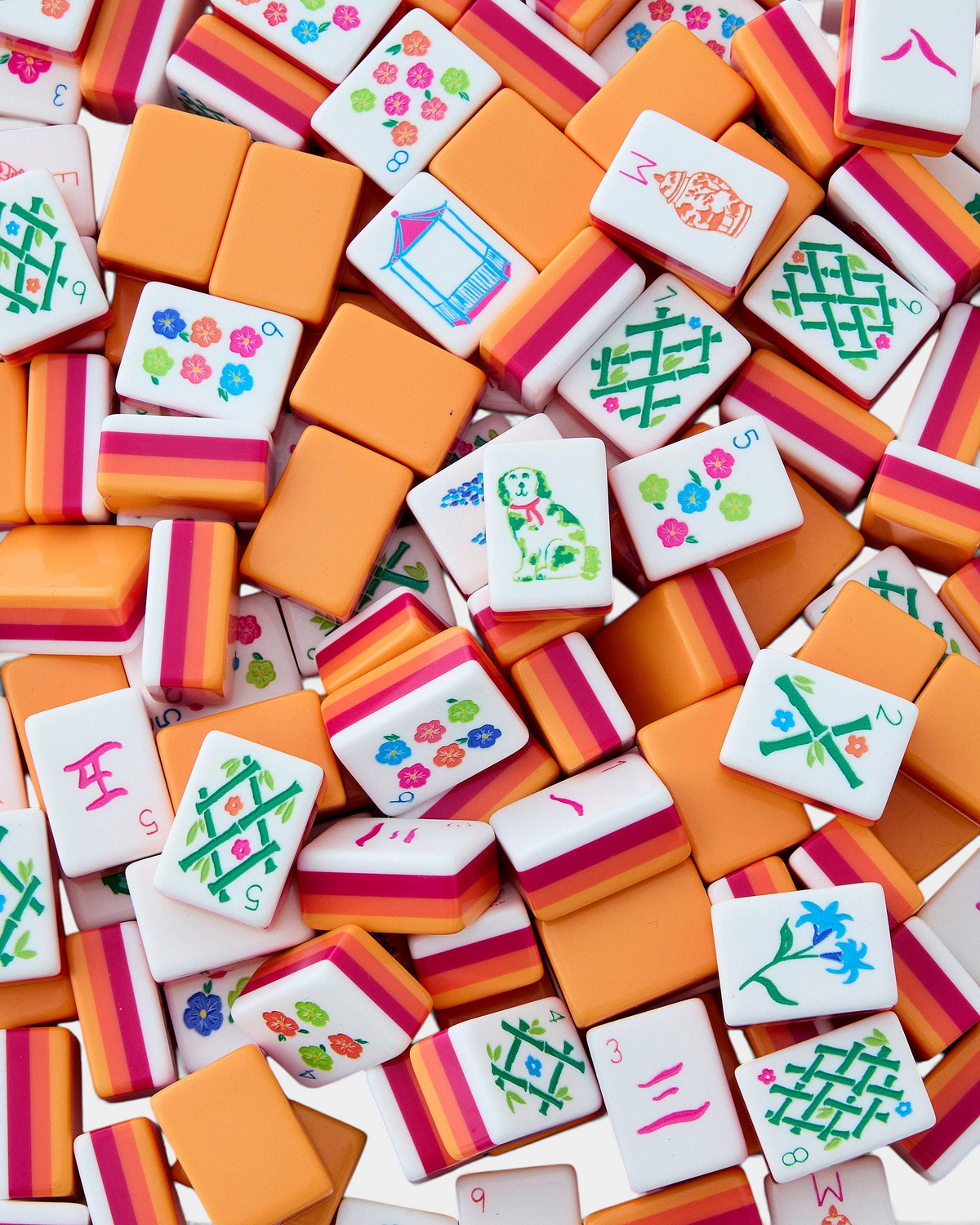 The Copper Shed Sunset Tiles featuring vibrant coral, orange, and neon pink acrylic mahjong pieces with floral designs.