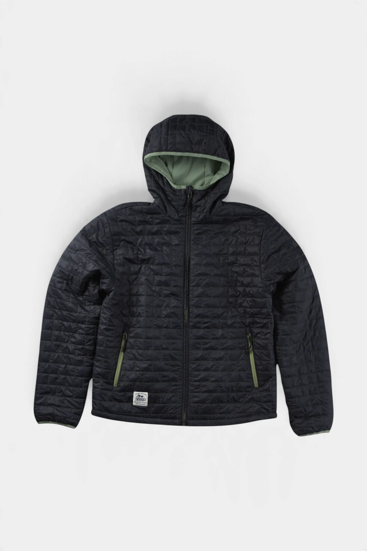 The Copper Shed Switch reversible insulated jacket in black with sage green lining and hood detail.