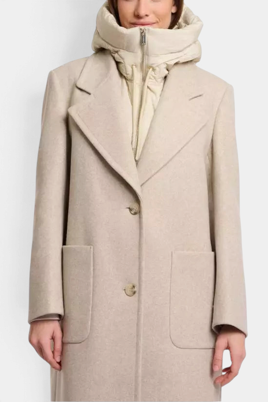 The Copper Shed Rino & Pelle Tabita padded bib in peated beige layered under a wool coat on a model