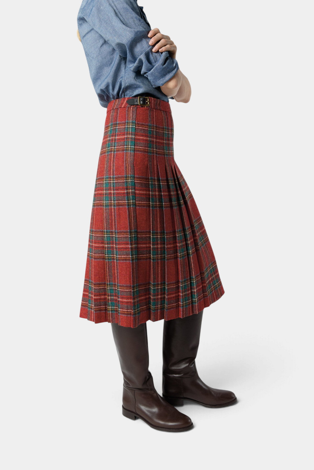 The Copper Shed Royal Stewart tartan wool kilt skirt with adjustable leather hip straps worn with tall brown boots.