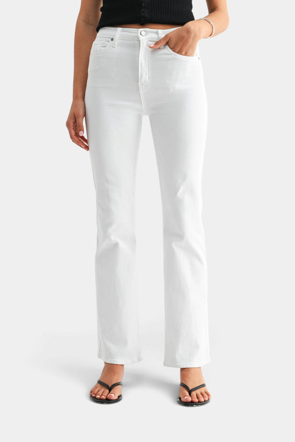 The Copper Shed high-rise optic white denim jeans with a relaxed fit and flared hem worn by a model