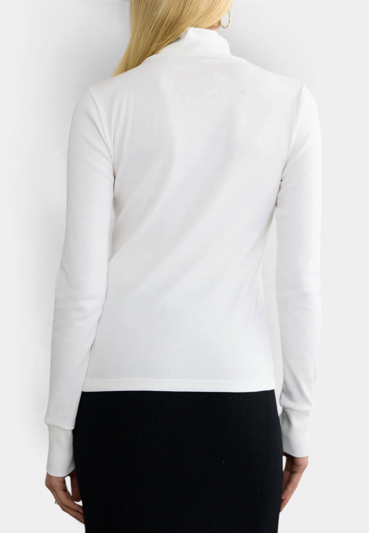 The Copper Shed white long sleeve ribbed organic cotton turtleneck worn by a blonde model, back view.