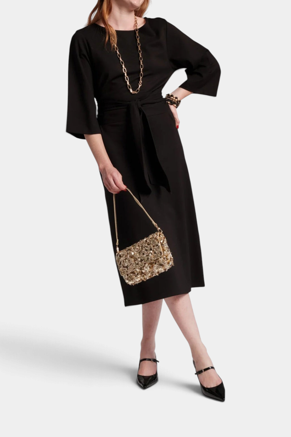 The Copper Shed Whitney wrap dress in black midi length with a crew neck and adjustable waist tie on a model