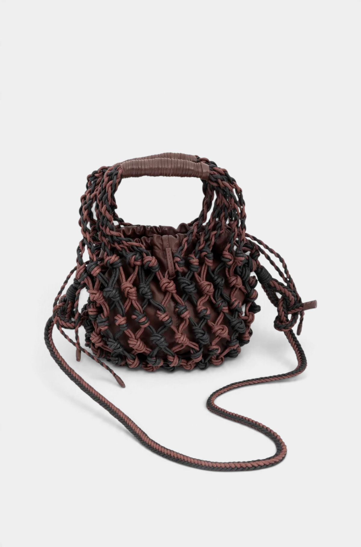 The Copper Shed net handbag featuring hand-woven black and brown cotton tubes with an inner leather pouch and strap.