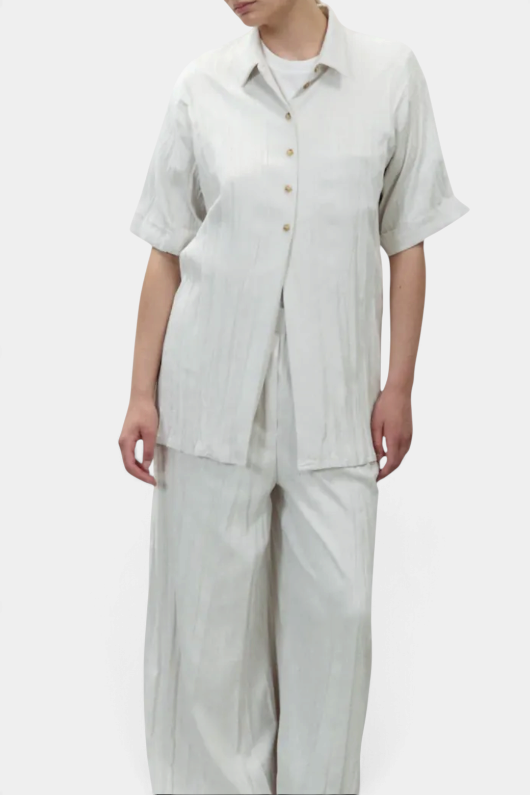 The Copper Shed Wrinkled Dainetto shirt in off-white faux suede with a relaxed fit, collar, and cuffed short sleeves.