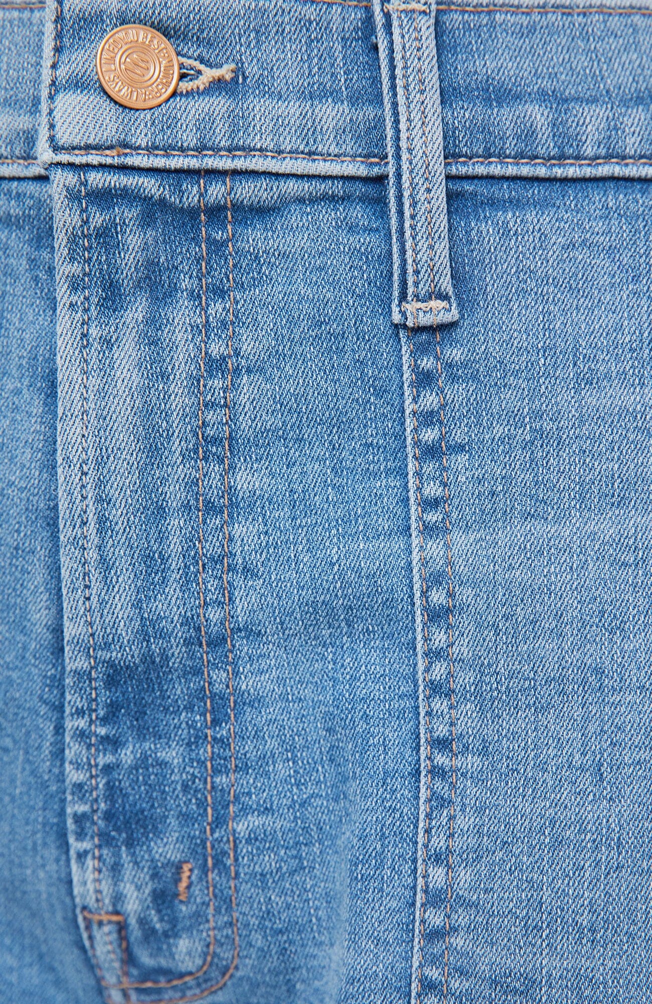 Close-up of blue denim fabric with a coin for scale