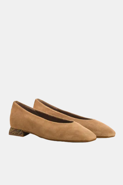 Pair of brown suede shoes on a light beige background